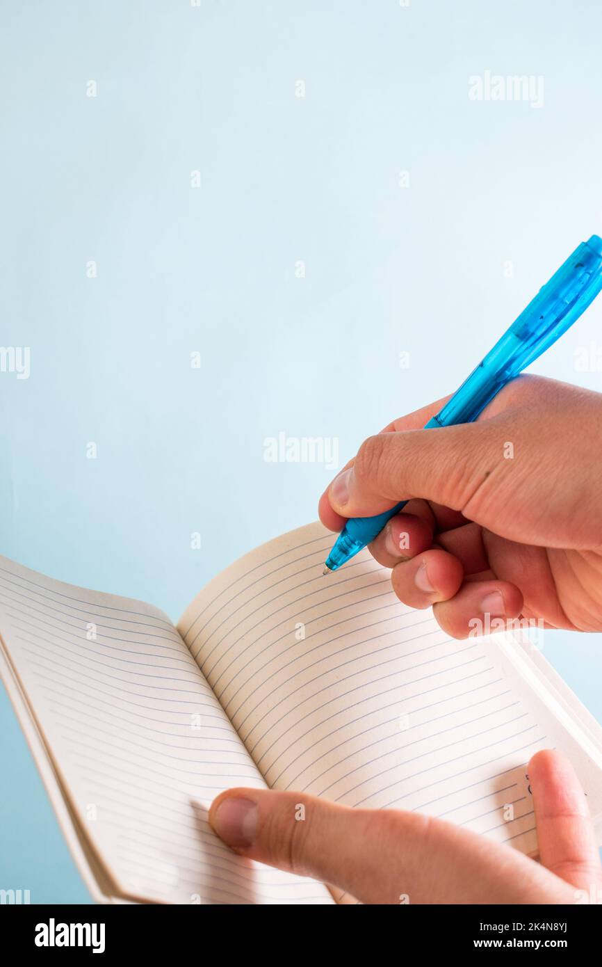 Hand writting on notebook with blue pen Stock Photo