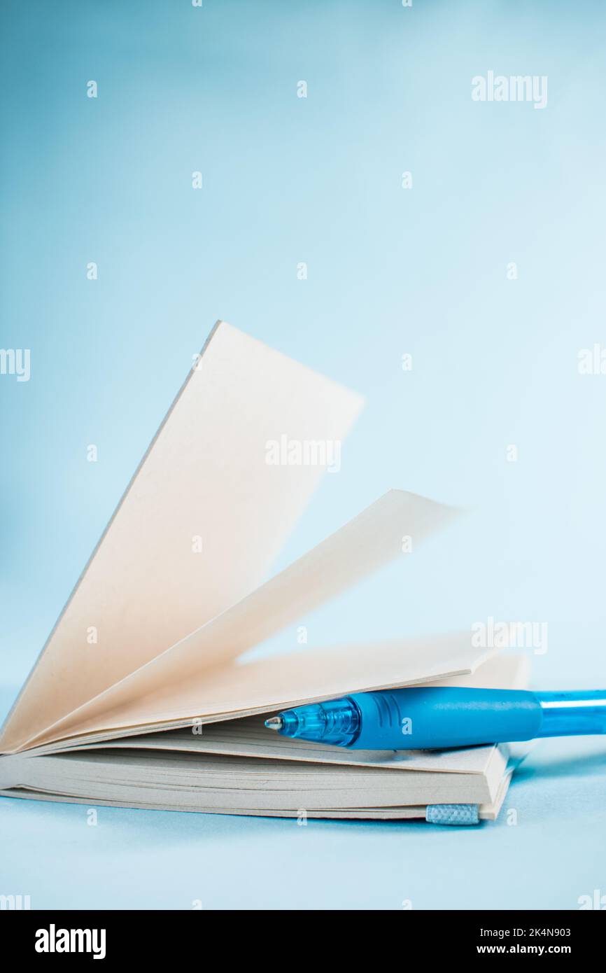 Blue pen in a notebook on blue background Stock Photo
