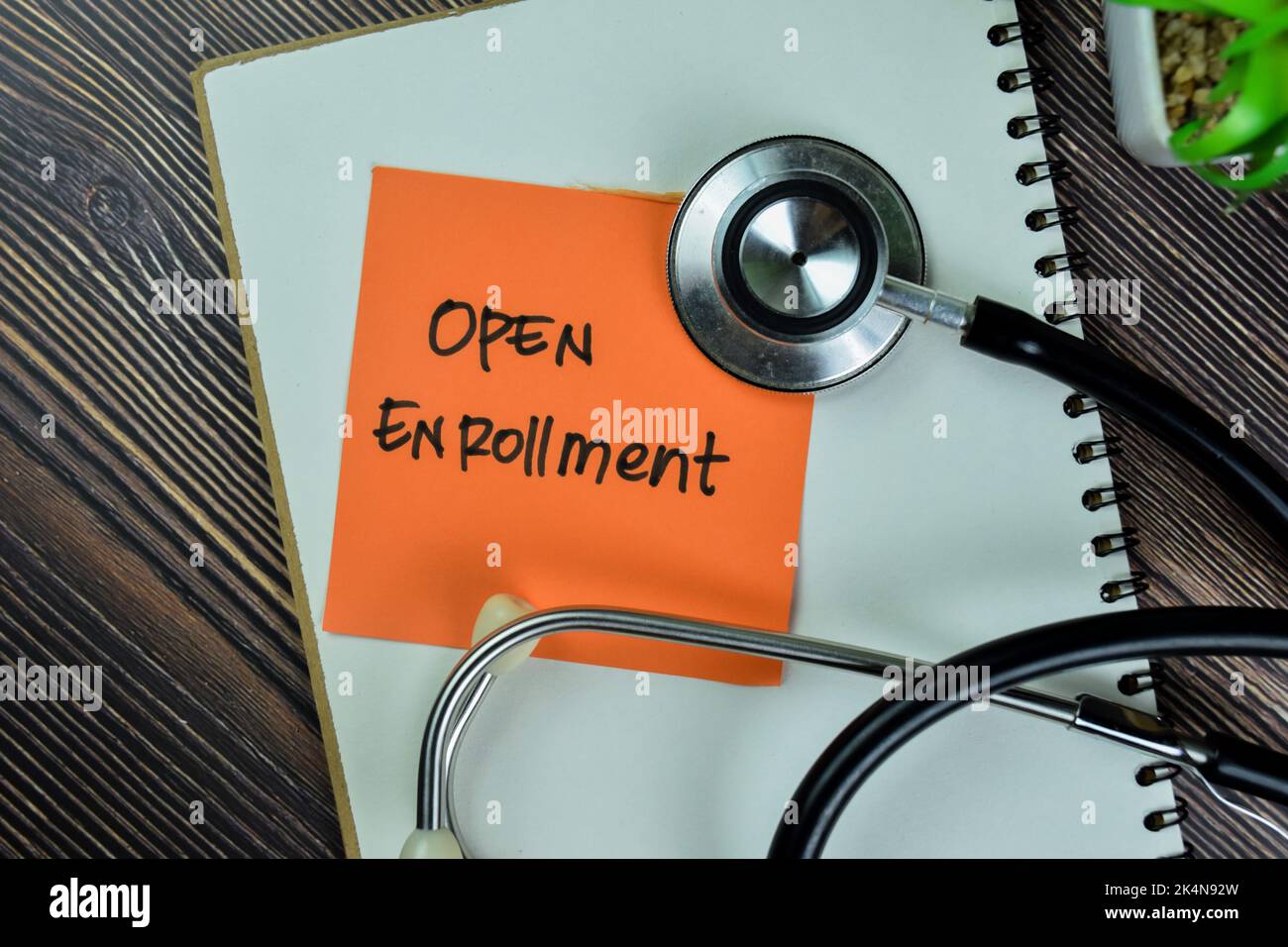 Concept of Open Enrollment write on sticky notes with stathoscope isolated on Wooden Table. Stock Photo