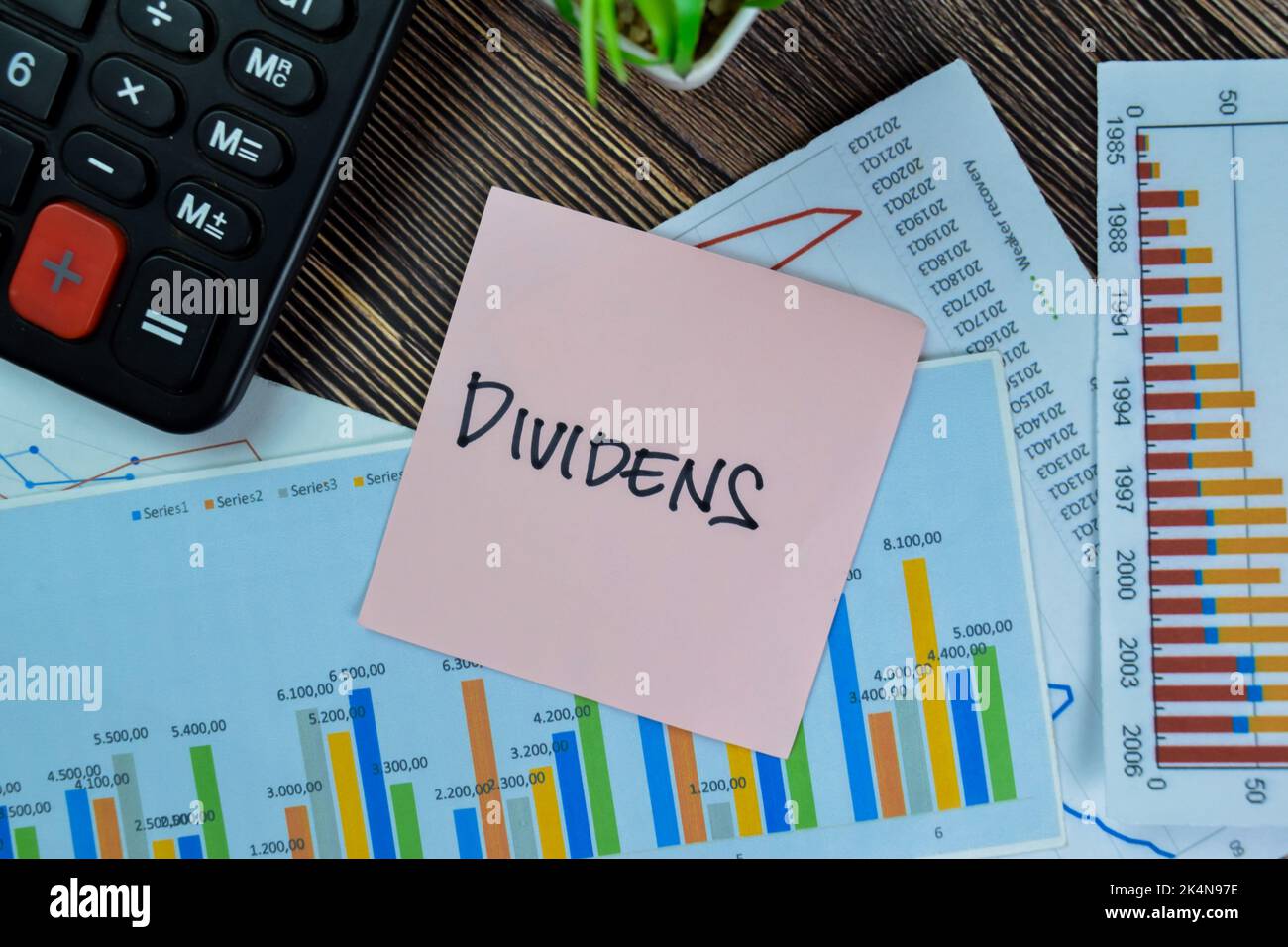 Concept of Dividens write on sticky notes isolated on Wooden Table. Stock Photo