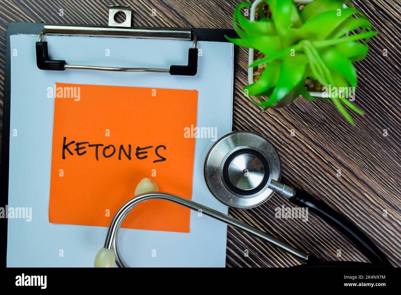 Concept of Ketones write on sticky notes with stethoscope isolated on Wooden Table. Stock Photo