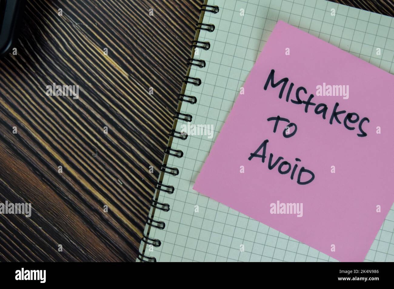 Concept of Mistakes to Avoid write on sticky notes isolated on Wooden Table. Stock Photo