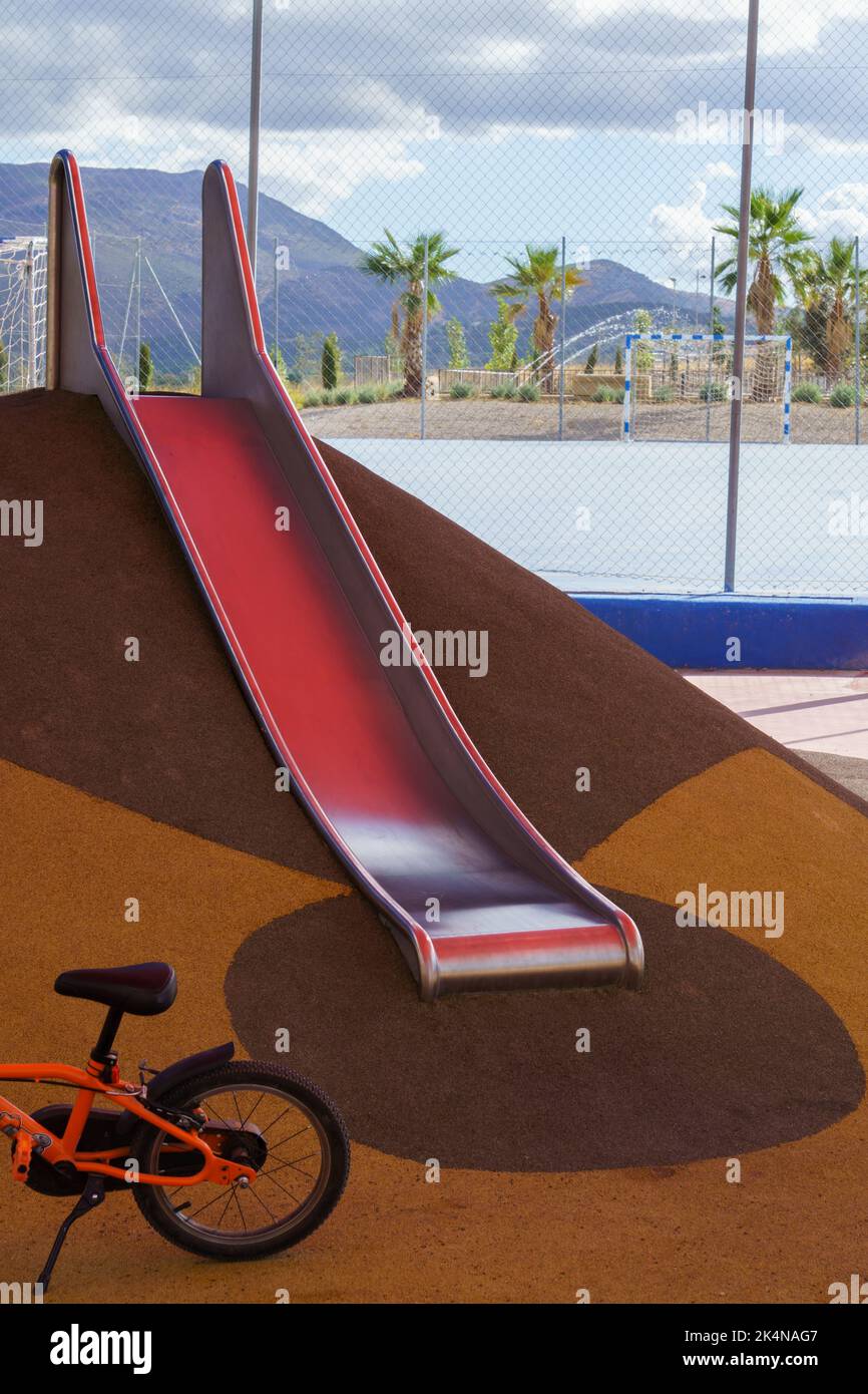 slide and bicycle in a playground, playground equipment for children Stock Photo