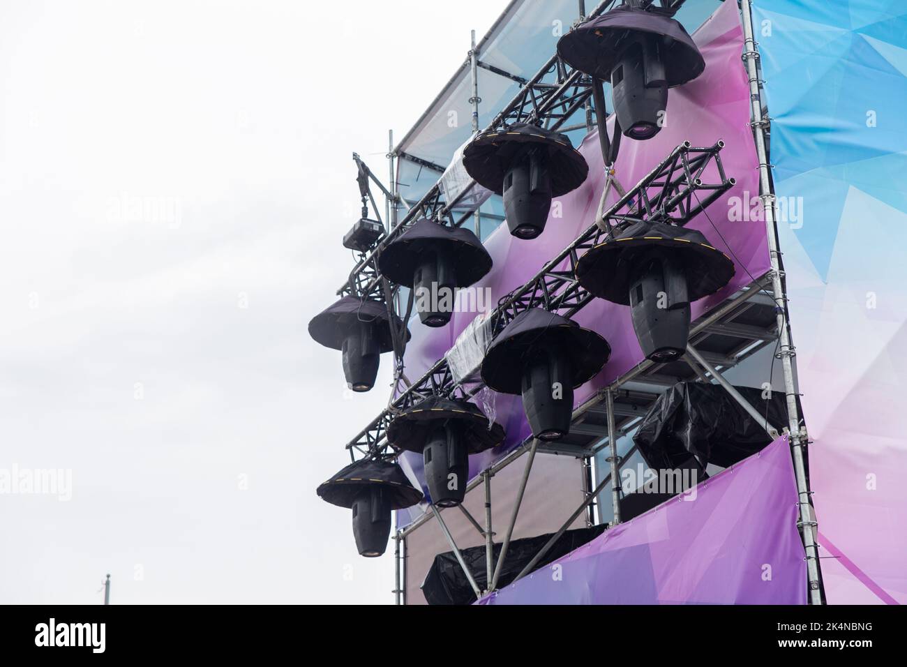 Professional lighting equipment high above an outdoor concert scene