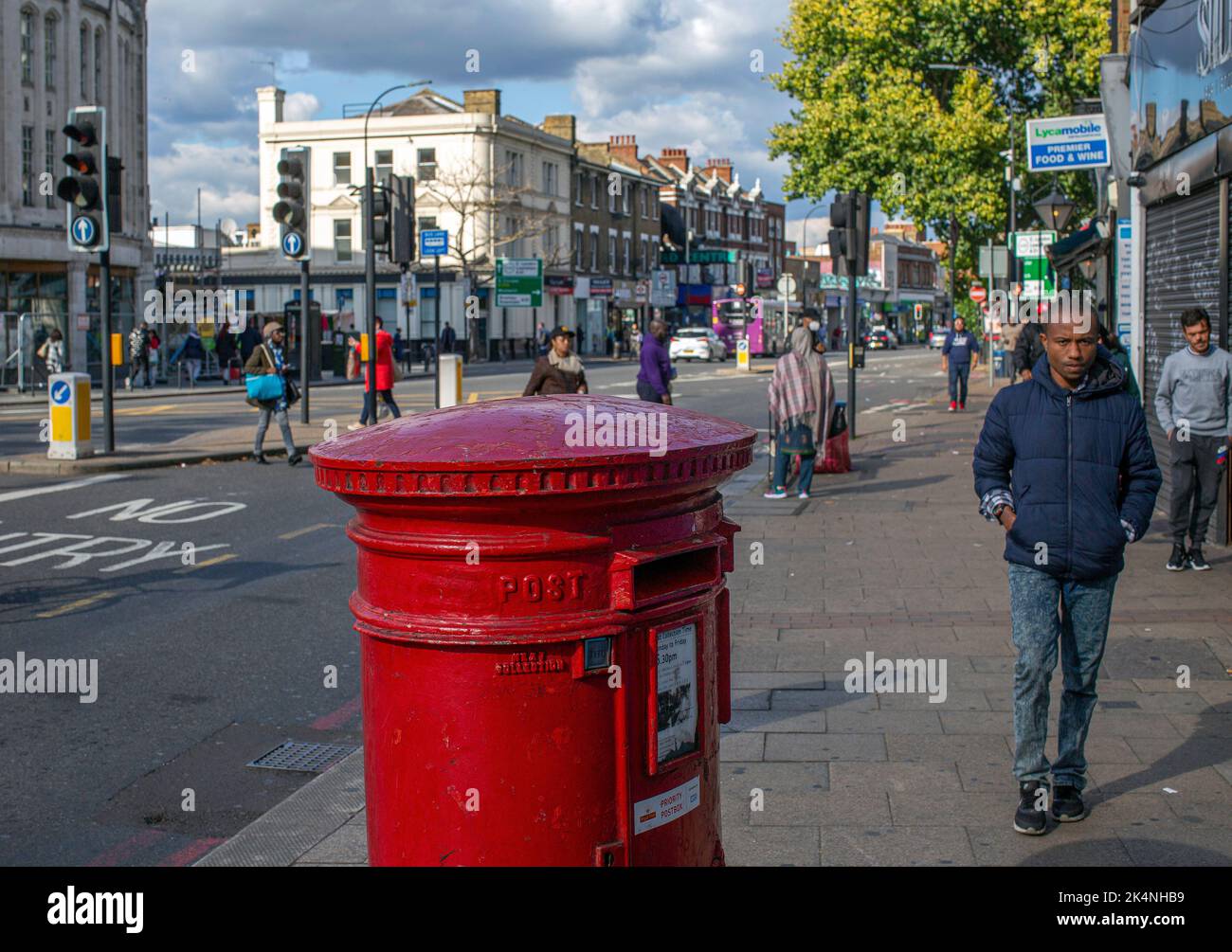 London, UK. Sept 29 2022 . Workers Union take further national strike action. Man walks by Traditional red post box in Lewisham,London ,England . Stock Photo