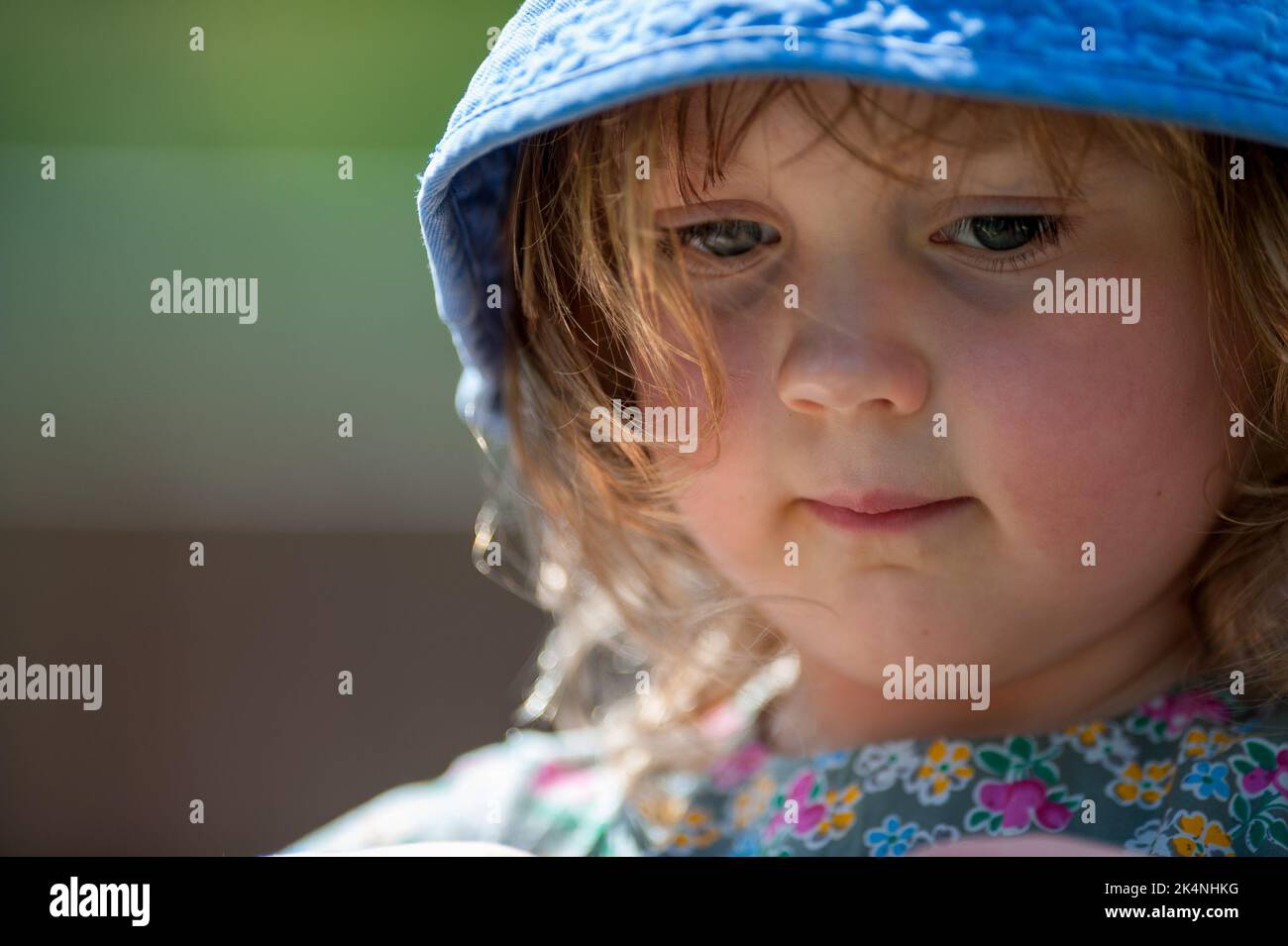 Girl in the sun wearing blue sun hat Stock Photo Alamy