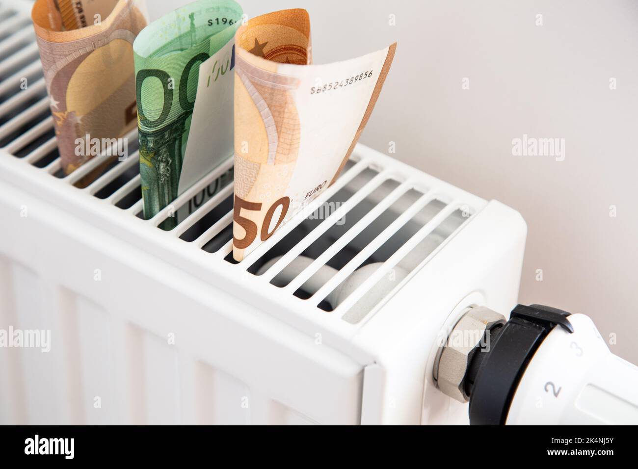 Radiator with thermostat and euro money banknotes. Expensive gas