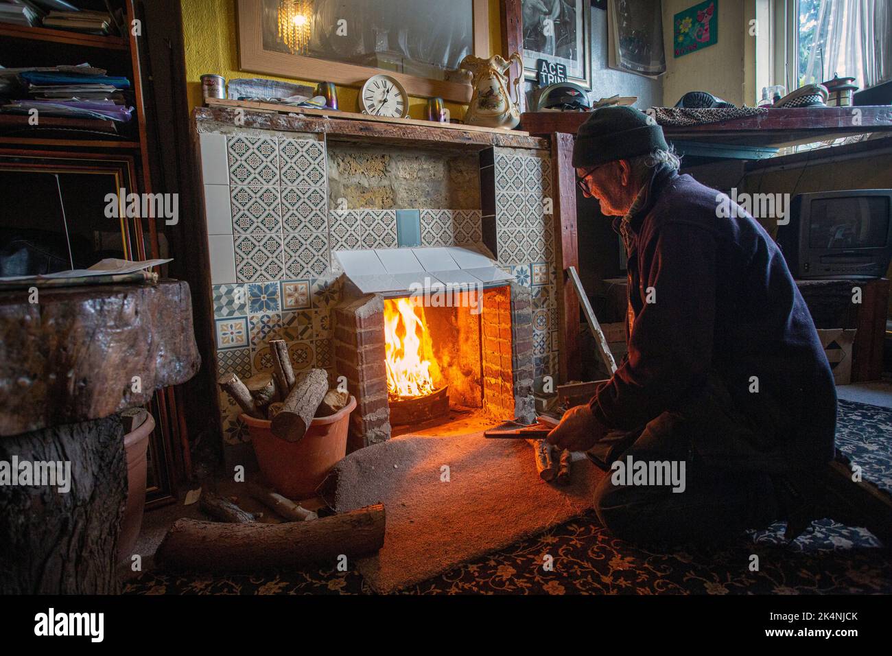 London, UK. Sept 29 2022 .Man was opening up his bricked up fireplace in the living room so he could burn wood to stay warm this winter. Stock Photo