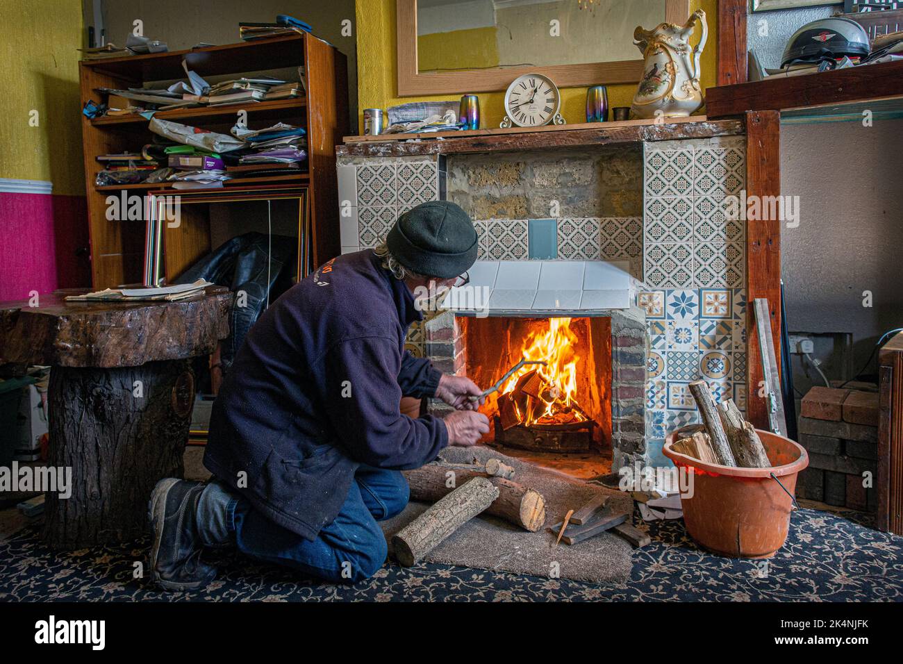 London, UK. Sept 29 2022 .Man was opening up his bricked up fireplace in the living room so he could burn wood to stay warm this winter. Stock Photo