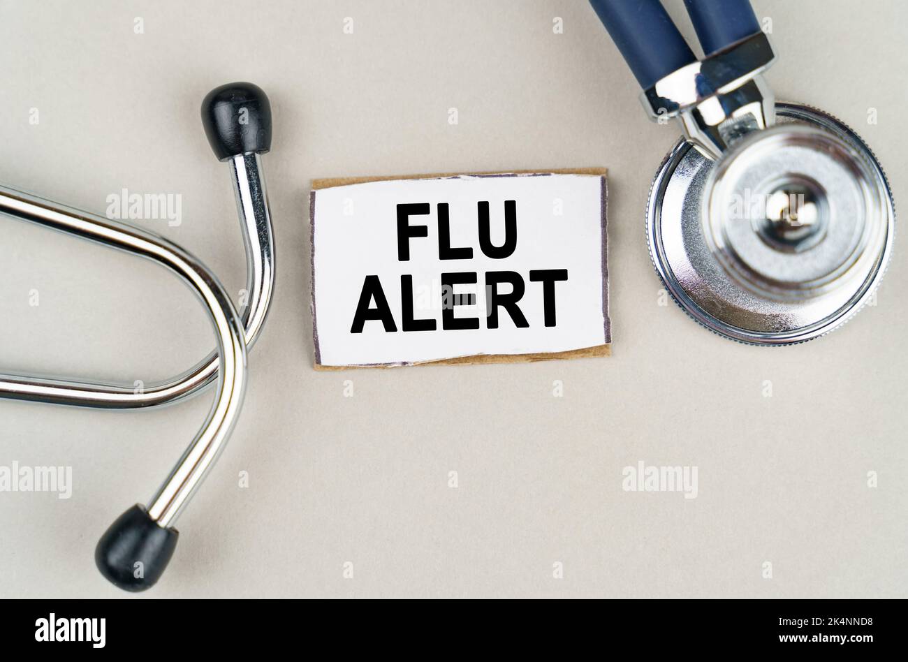Medical concept. On a gray background, a stethoscope and a cardboard sign with the inscription - Flu alert Stock Photo