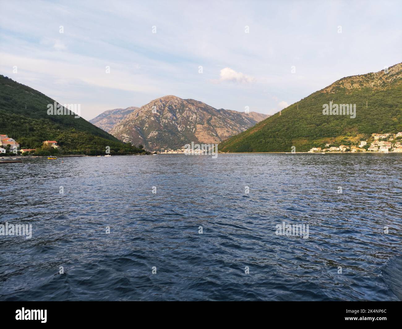 A beautiful view of a lake water between green hills on a sunny day ...