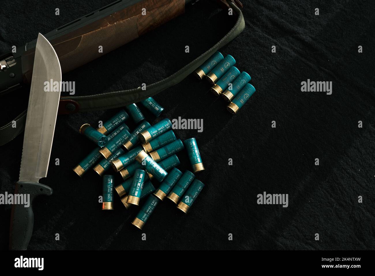 Weapon on black cloth: knife, rifle, shells,top view. Top view of knife ...