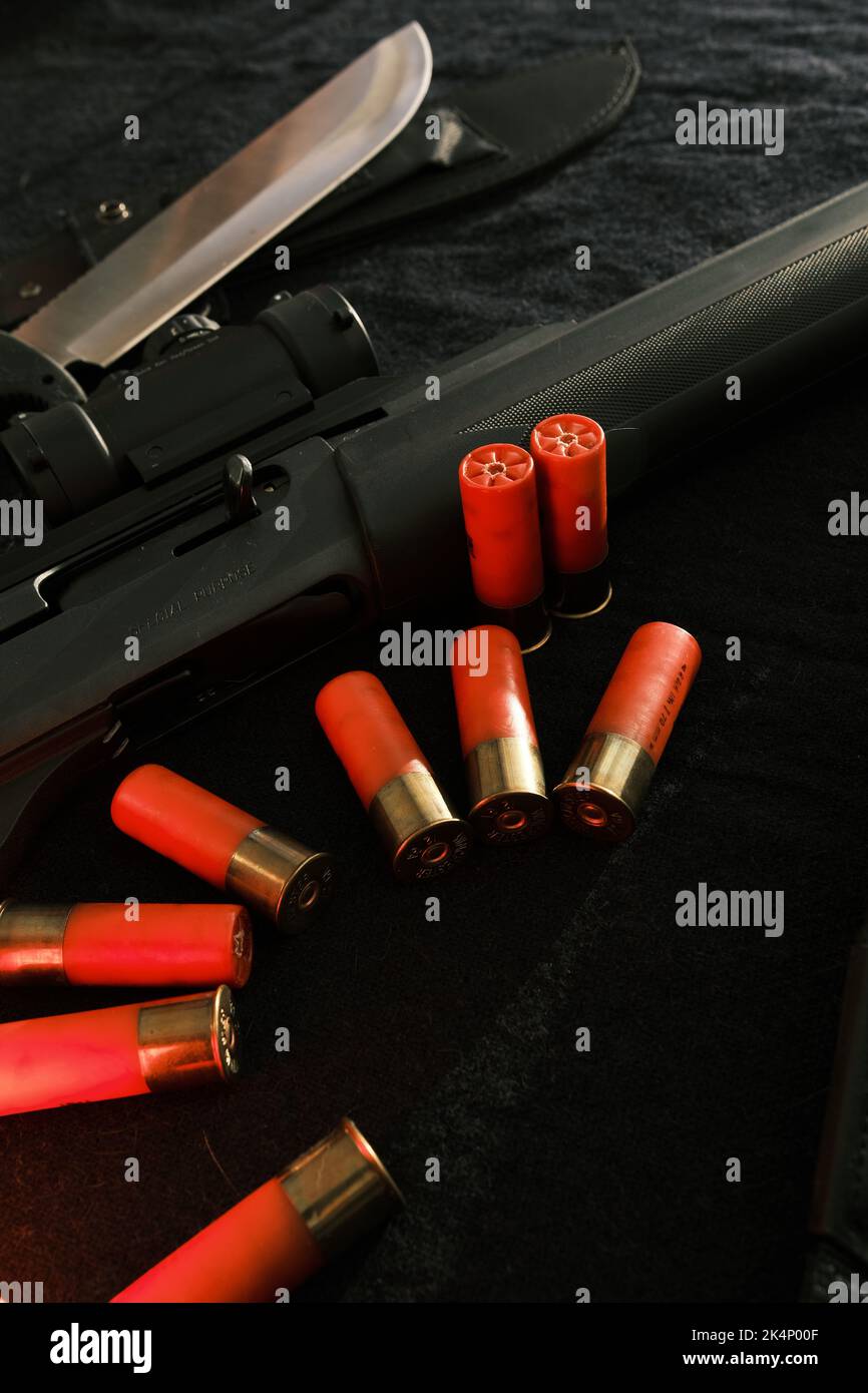 Weapon on black cloth: knife, rifle, shells,top view. Top view of knife ...