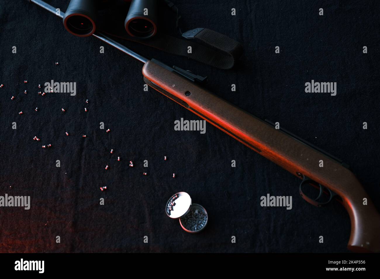 Rifle gun with air pellets for hunting on cloth dark background Stock