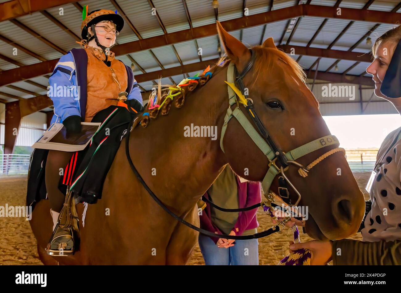 A child rides a therapy horse at a Halloween costume party for riders in the Therapeutic Equestrian program, Oct. 29, 2012, in West Point, Mississippi. Stock Photo