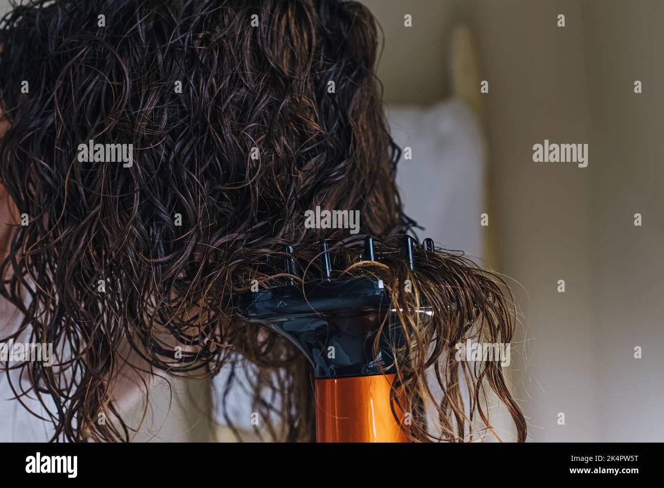 Woman diffusing her hair with a dryer. Drying hair according to a curly ...