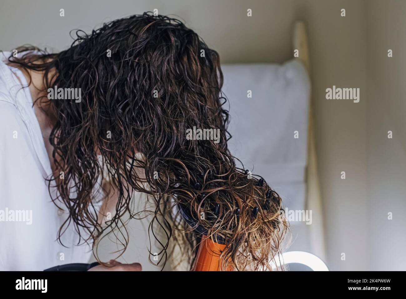 Woman diffusing her hair with a dryer. Drying hair according to a curly ...