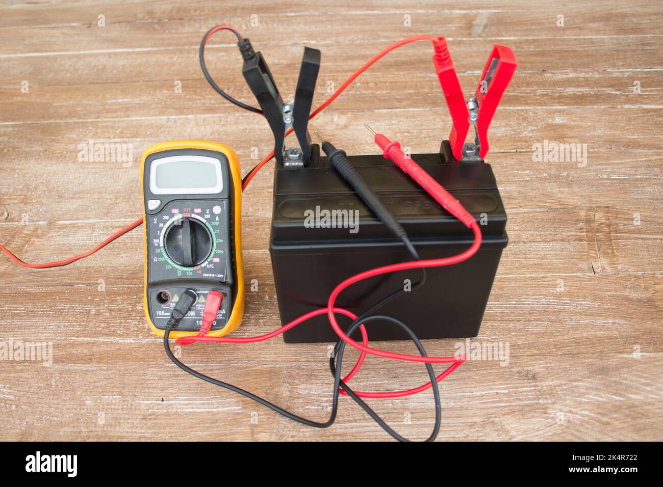 Image of a charging battery. Charging a lead-acid battery for cars and motorcycles with a multimeter to measure its charge Stock Photo