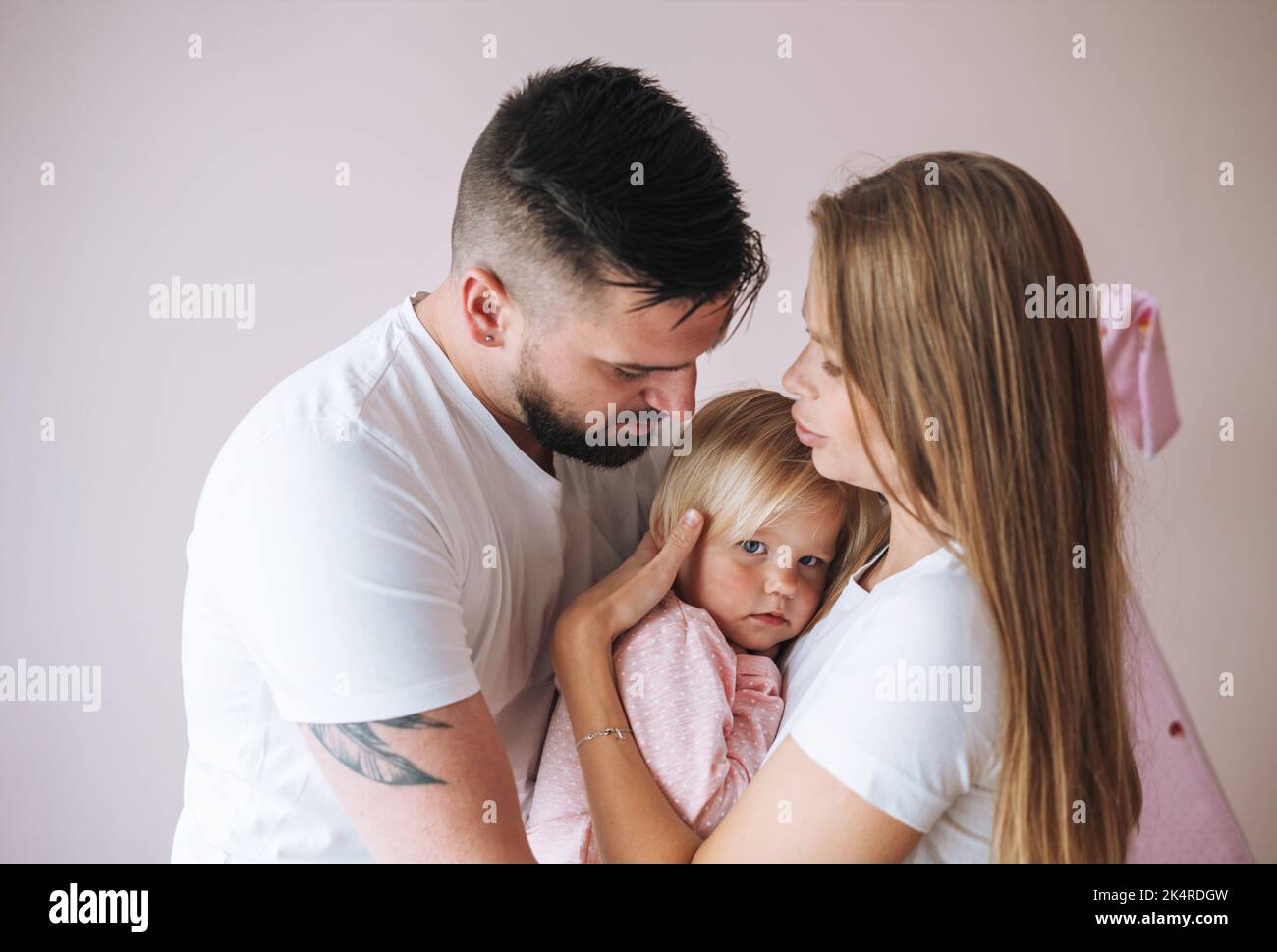 Happy multinational family father young man and mother with baby girl little daughter having fun in children room at home Stock Photo