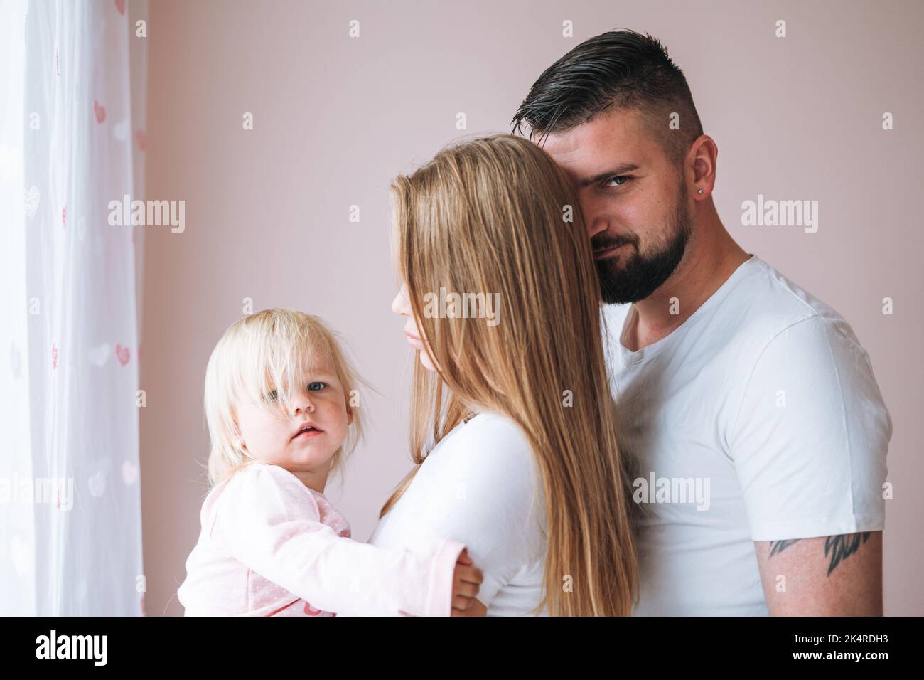 Happy multinational family father young man and mother with baby girl little daughter having fun in children room at home Stock Photo