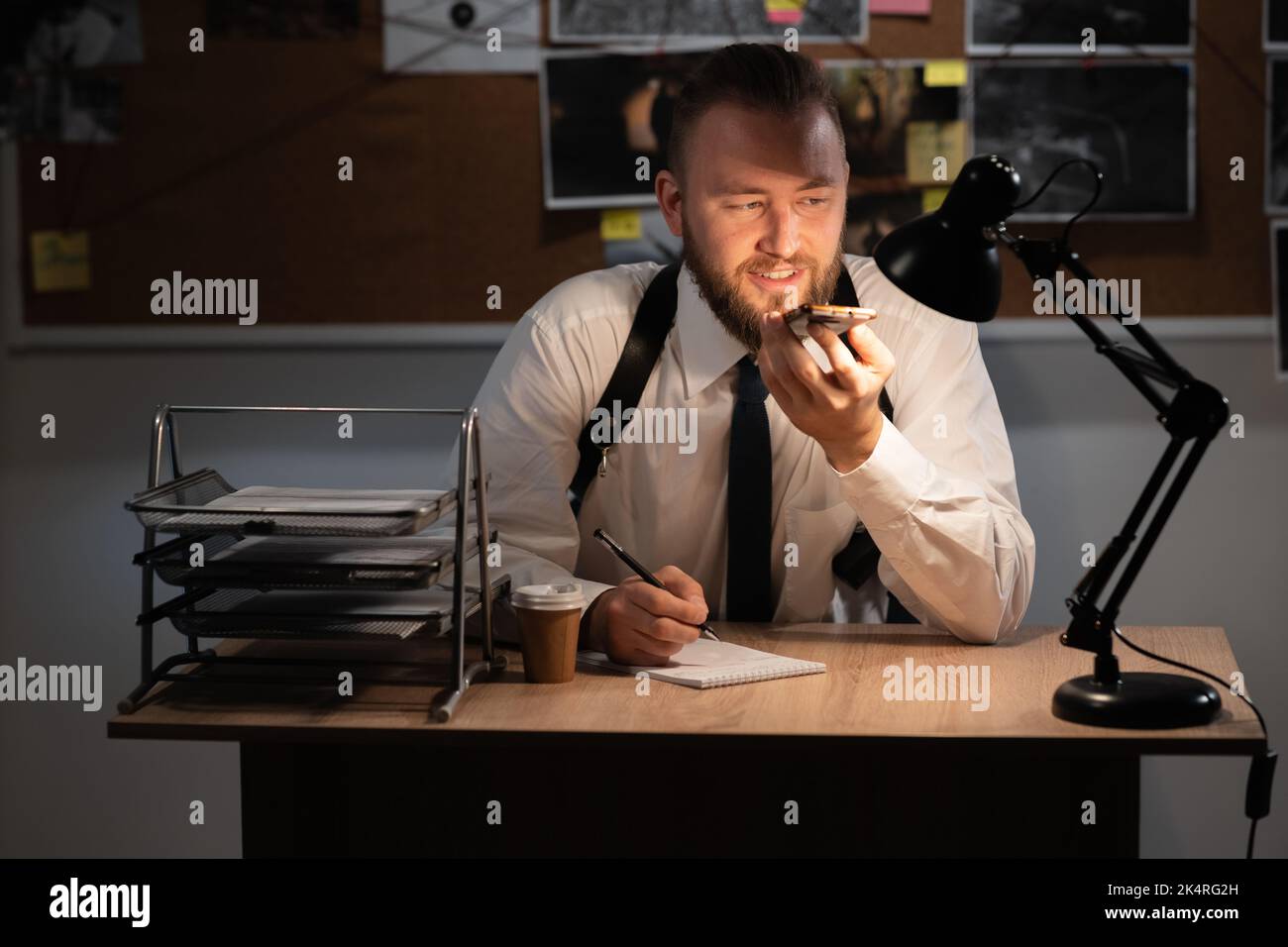 Private detective working in the office at night, investigator