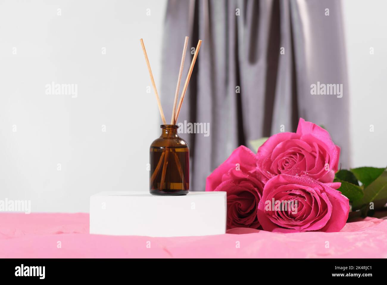 Aromatic reed air freshener and roses. amber glass bottle with sticks