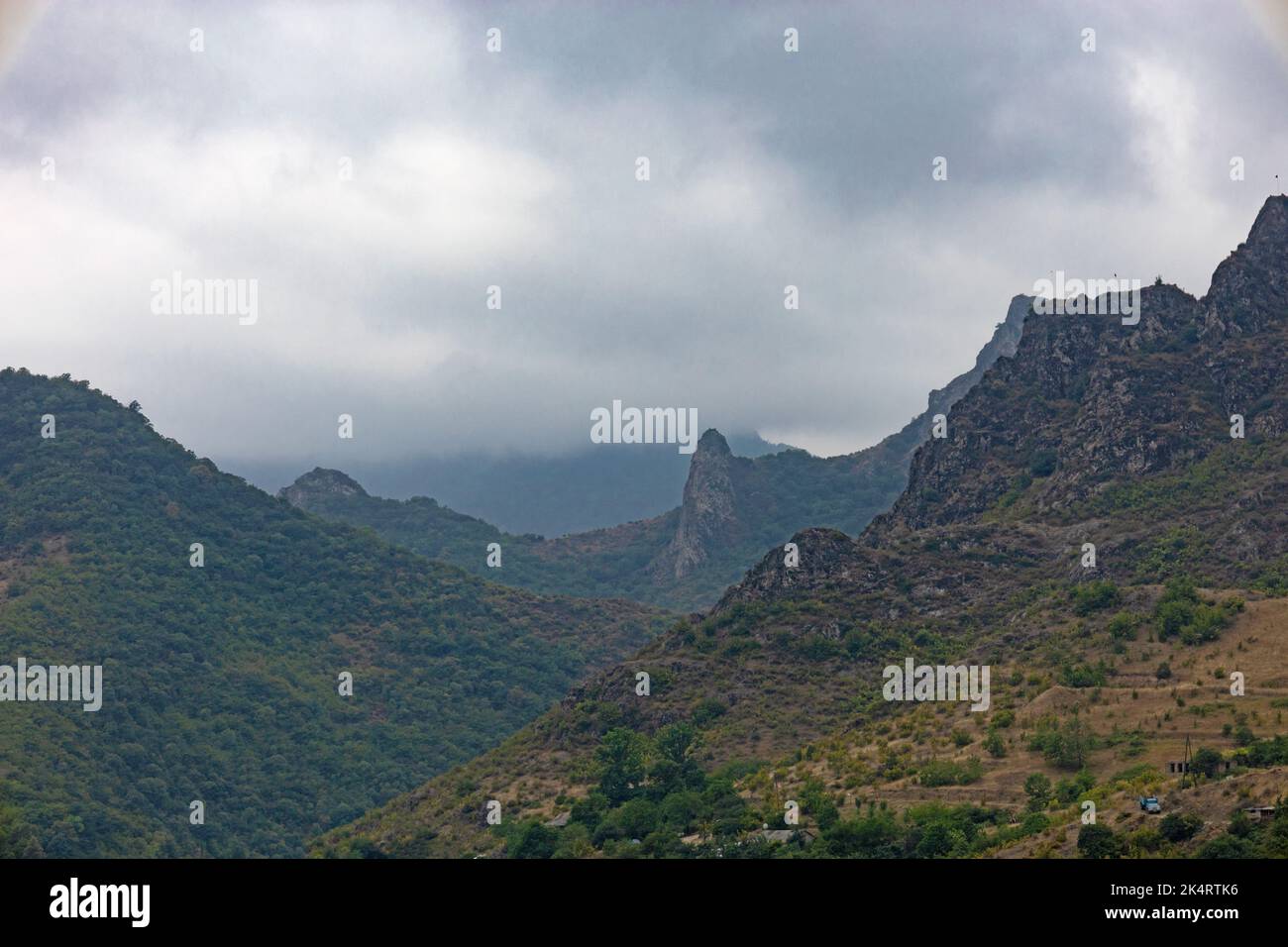 Mountains covered with forest on a foggy day, under low hanging clouds, in summer Stock Photo