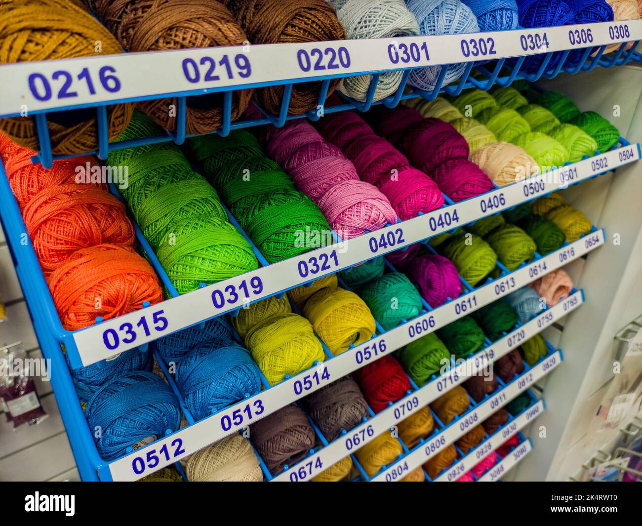 Shelf in a store with multicolored skeins of yarn. Needlework