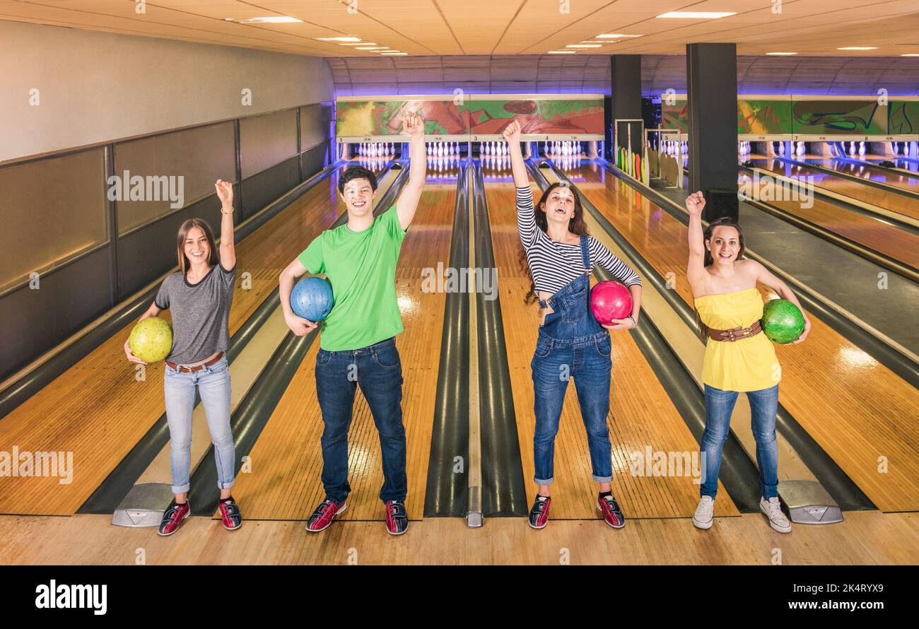 Best friends posing in victory position at bowling track looking at camera - Friendship and hobby concept with young playful people having fun and sha Stock Photo