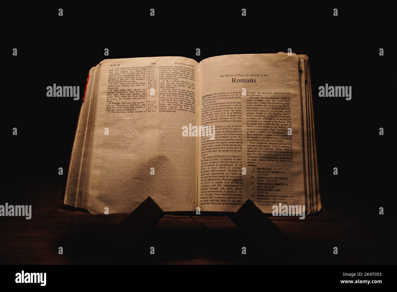 A closeup shot of a historic old Bible open on the Romans pages on ...