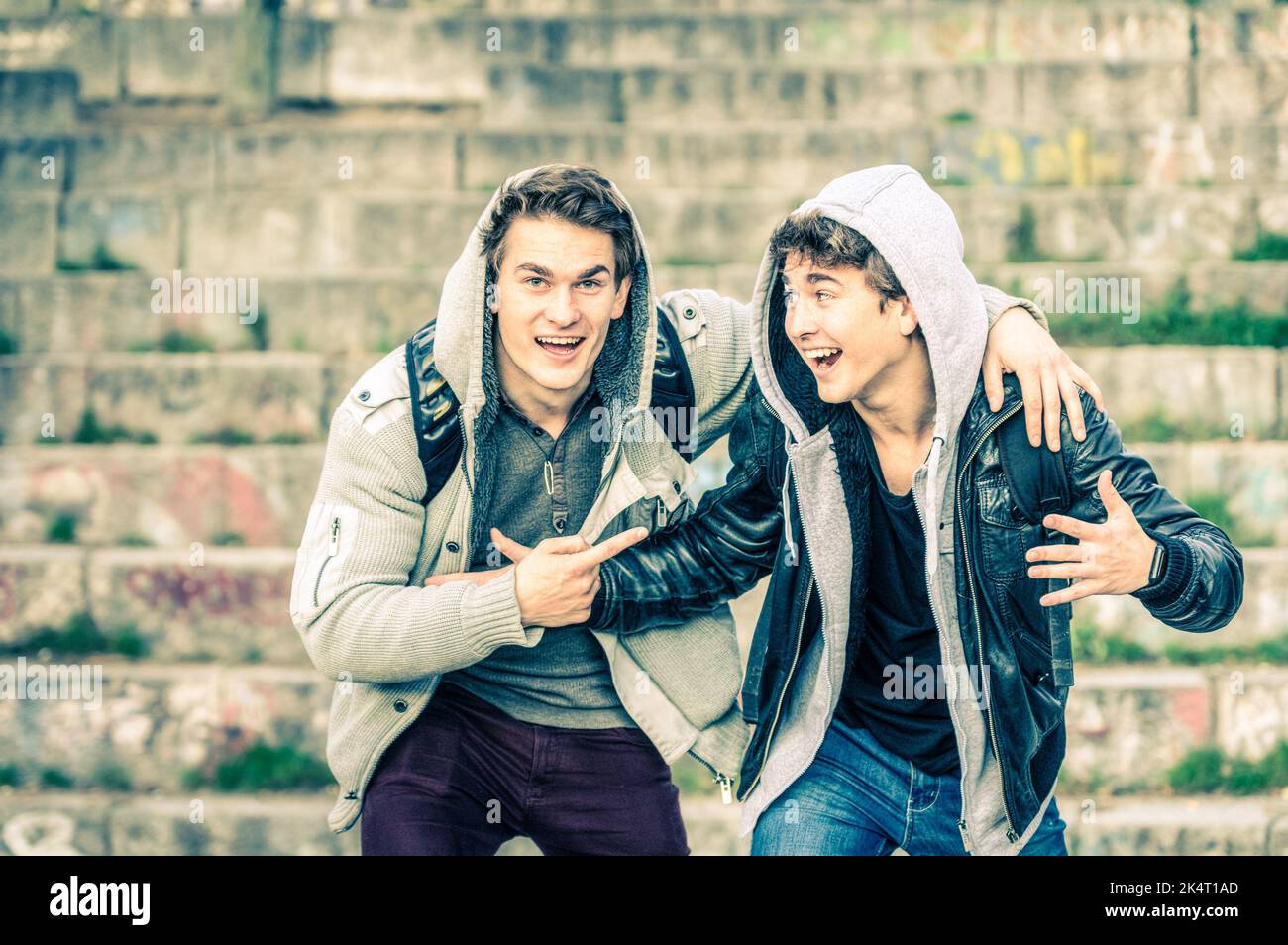 Young hipster brothers having fun with each other - Best friends sharing free time together in urban area outdoors - Handsome guys with winter fashion Stock Photo