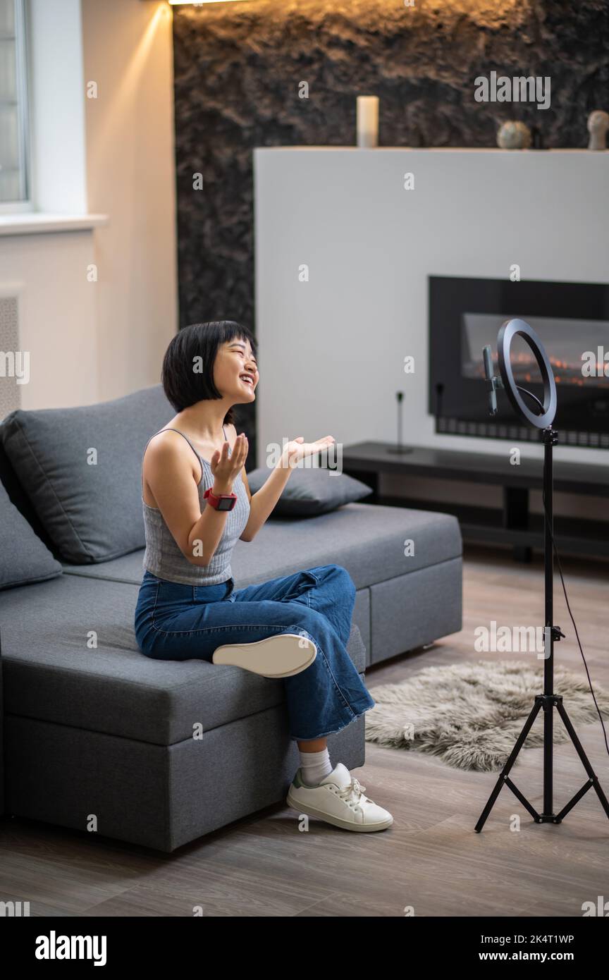 Cheerful vlogger conversing with her digital audience Stock Photo