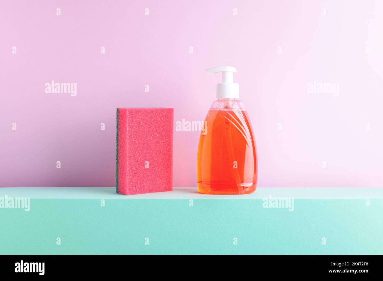 Front view of red dish washing liquid and foam sponge on decorative