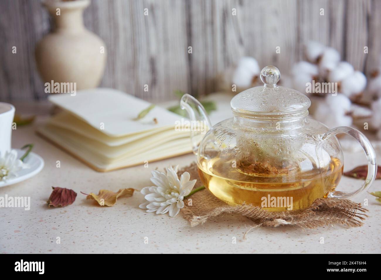 Aesthetic herbal linden tea in teapot with cup of tea. Wheat, leaves