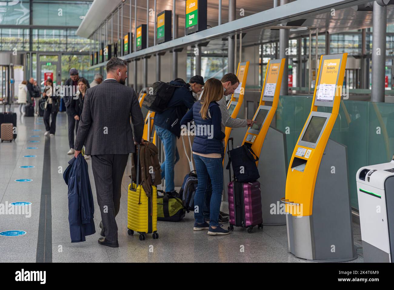 MUNICH, GERMANY - SEPTEMBER 29, 2022: Passengers performing check-in at the self-service check-in facilities at Terminal 2, Munich Airport. Stock Photo