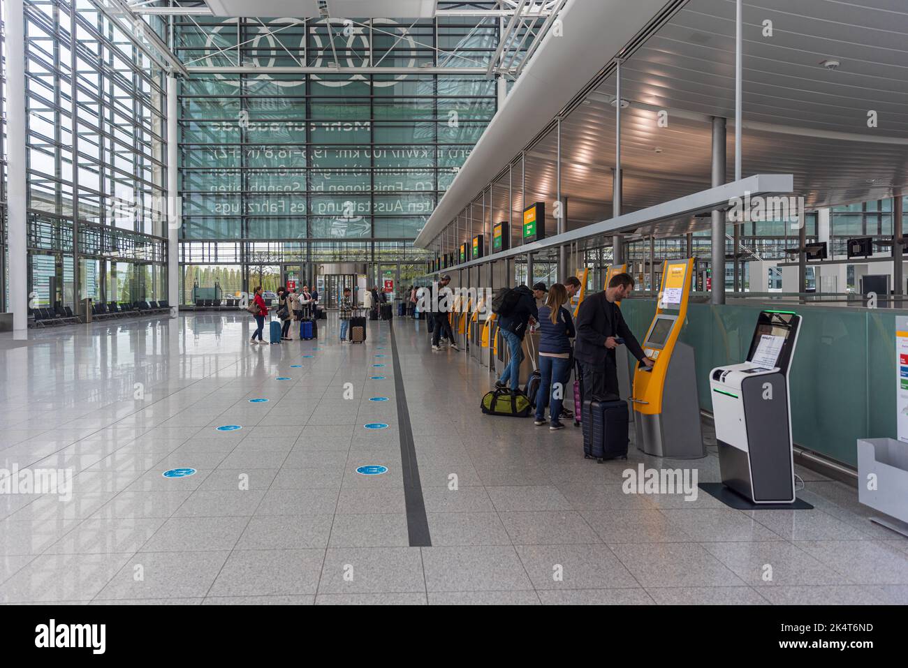 MUNICH, GERMANY - SEPTEMBER 29, 2022: Passengers performing check-in at the self-service check-in facilities at Terminal 2, Munich Airport. Stock Photo