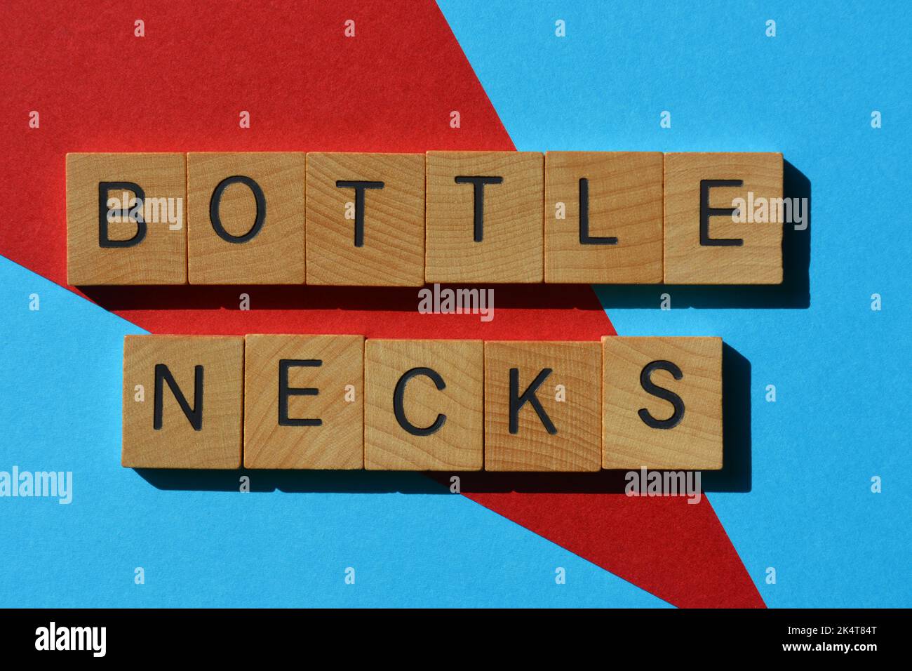 Bottle Necks, business buzzword, a problem in project management resulting in work pilling up, phrase in wooden alphabet letters isolated on backgroun Stock Photo