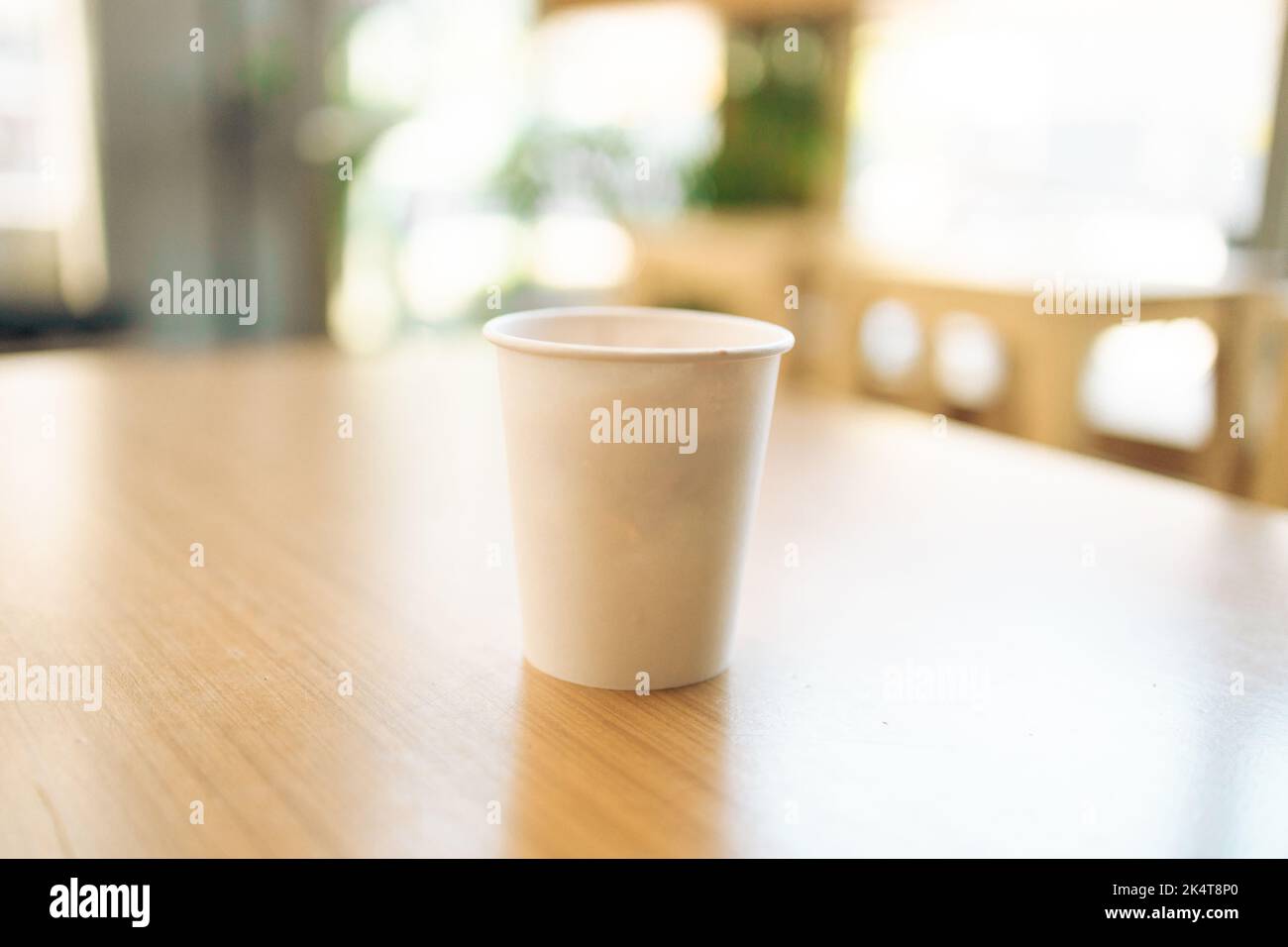 Paper coffee cup on a wood table in coffee shop Stock Photo - Alamy