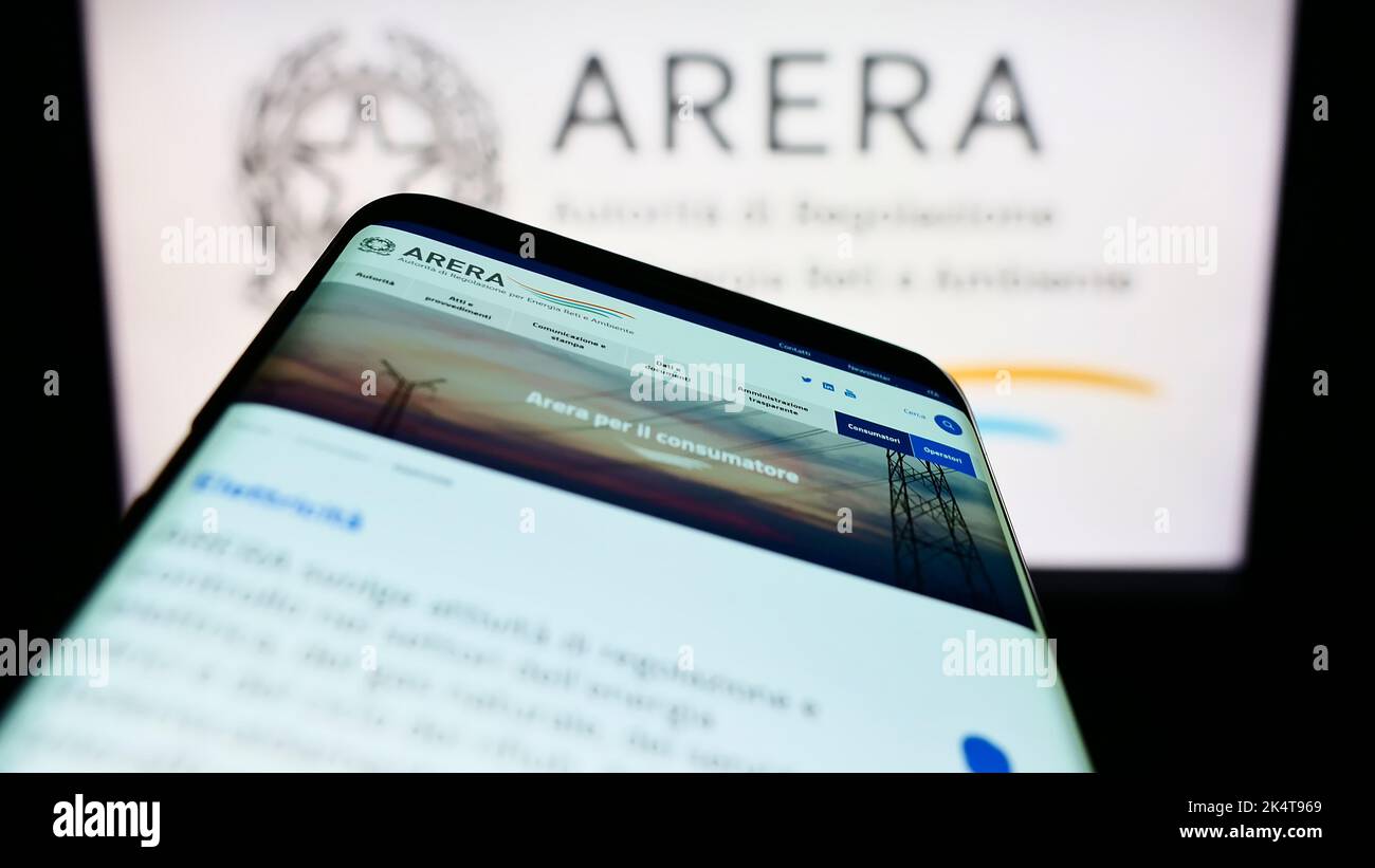 Smartphone with website of Italian regulation authority ARERA on screen in front of logo. Focus on top-left of phone display. Stock Photo