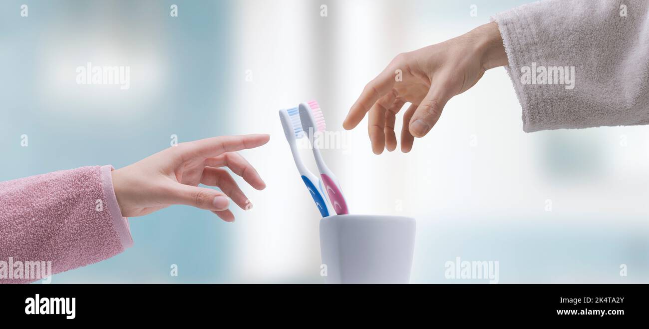 Man and woman taking their toothbrushes in the bathroom, oral hygiene