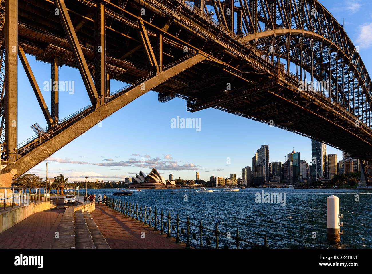 The Sydney Opera House and Circular Quay visible beneath the Sydney Harbour Bridge at golden hour Stock Photo