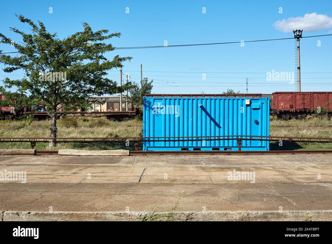 Blue container next to industrial area, train cars in background Stock ...