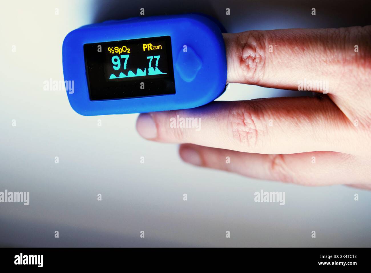 hnad with pulse oximeter showing patient's saturation and pulse Stock