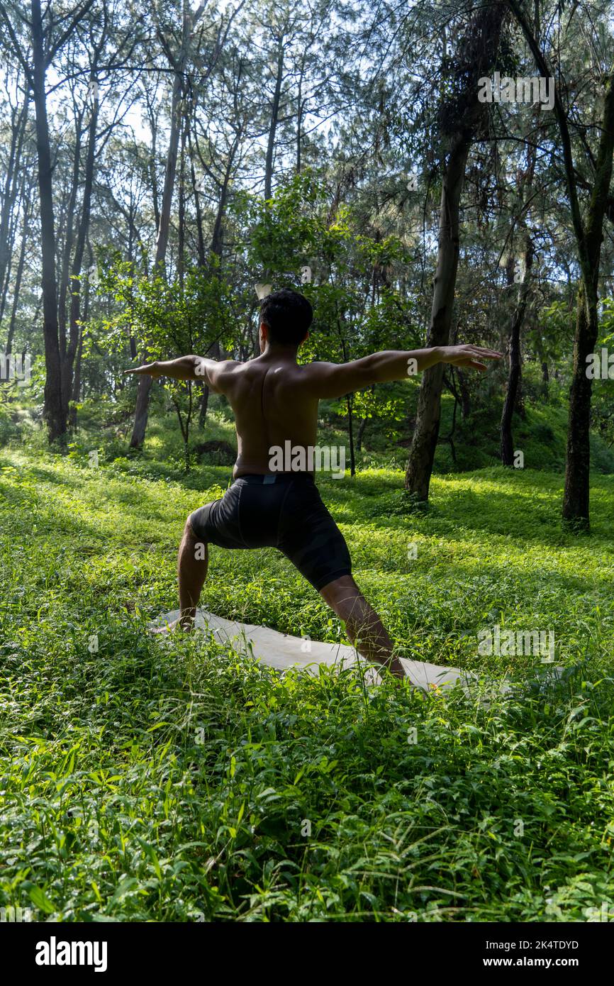 man seen up close, without shirt doing stretches on yoga mat, exercise
