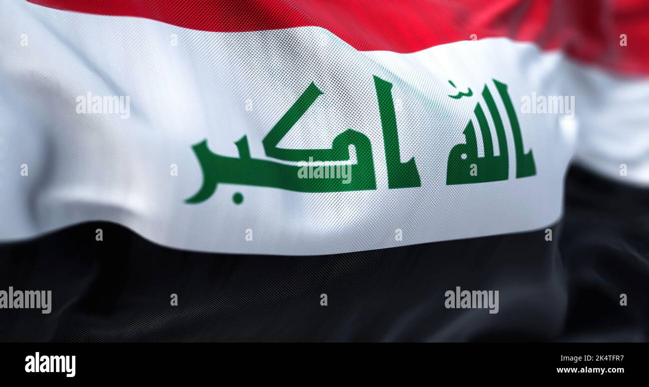 Close-up view of the Iraq national flag waving in the wind. The Republic of Iraq is a West Asian state. Fabric textured background. Selective focus Stock Photo