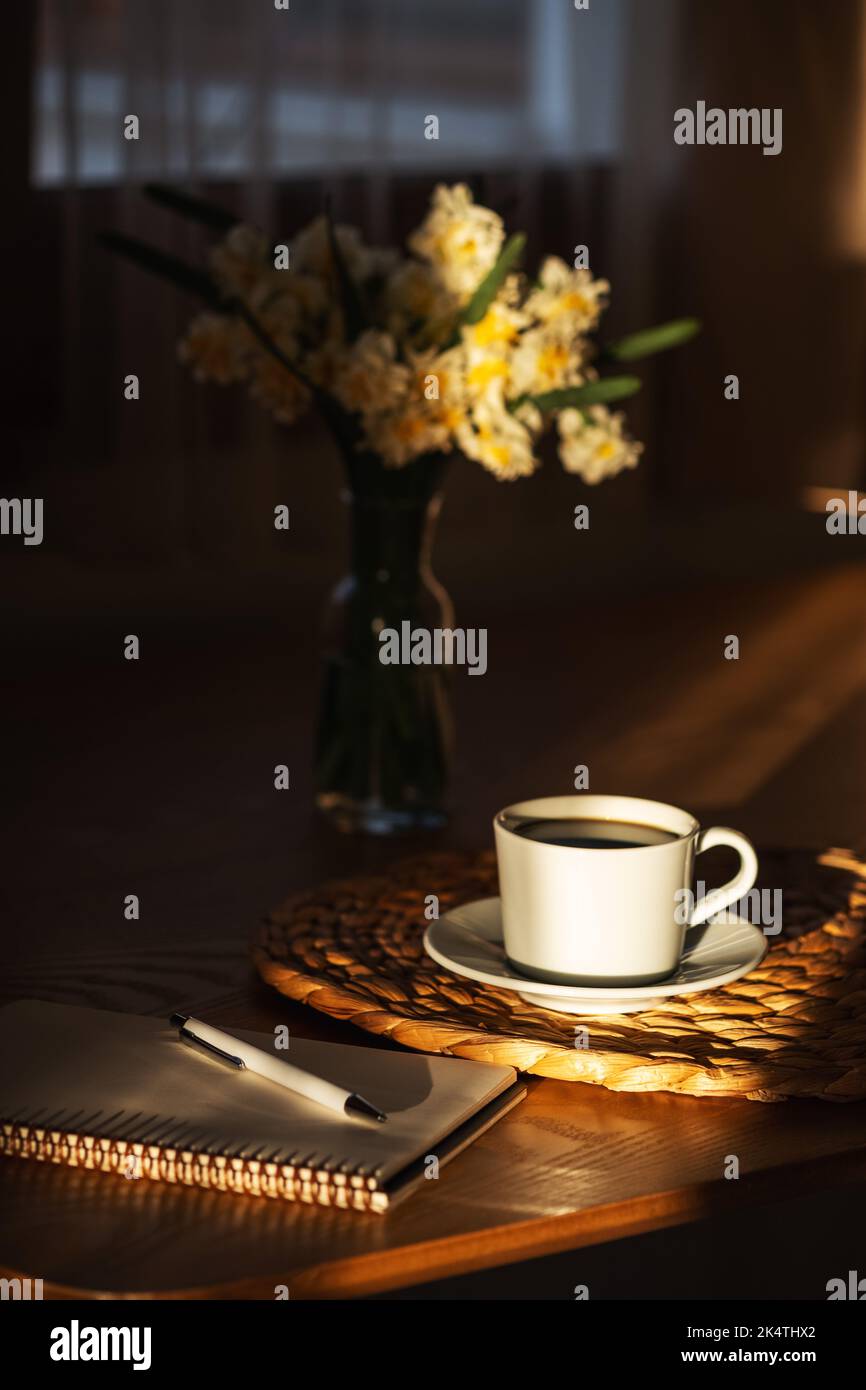 https://c8.alamy.com/comp/2K4THX2/cozy-breakfast-with-cup-of-coffee-flowers-and-open-notebook-on-rustic-wooden-table-morning-sunshine-with-shadows-2K4THX2.jpg