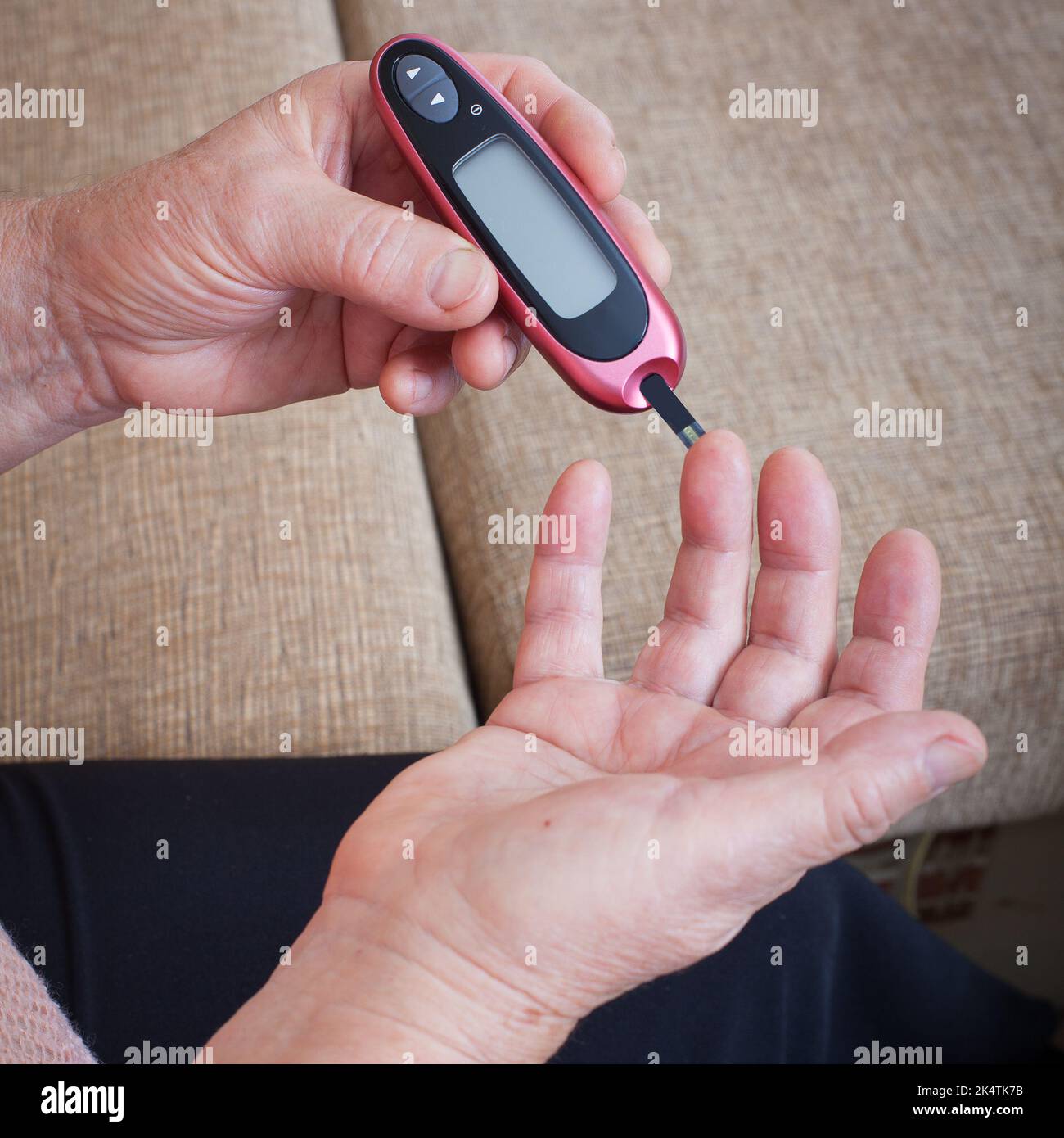 Senior woman checking blood sugar level using Closeup hand of old person with