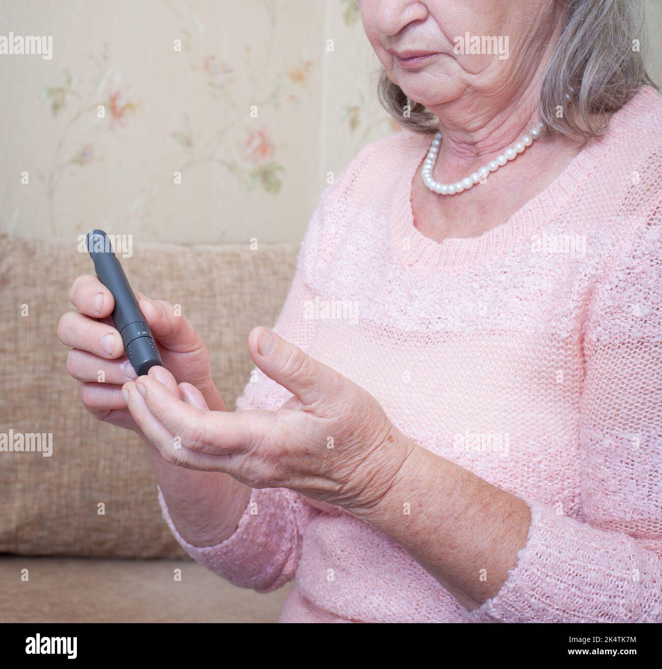 Senior woman checking blood sugar level using Closeup hand of old person with
