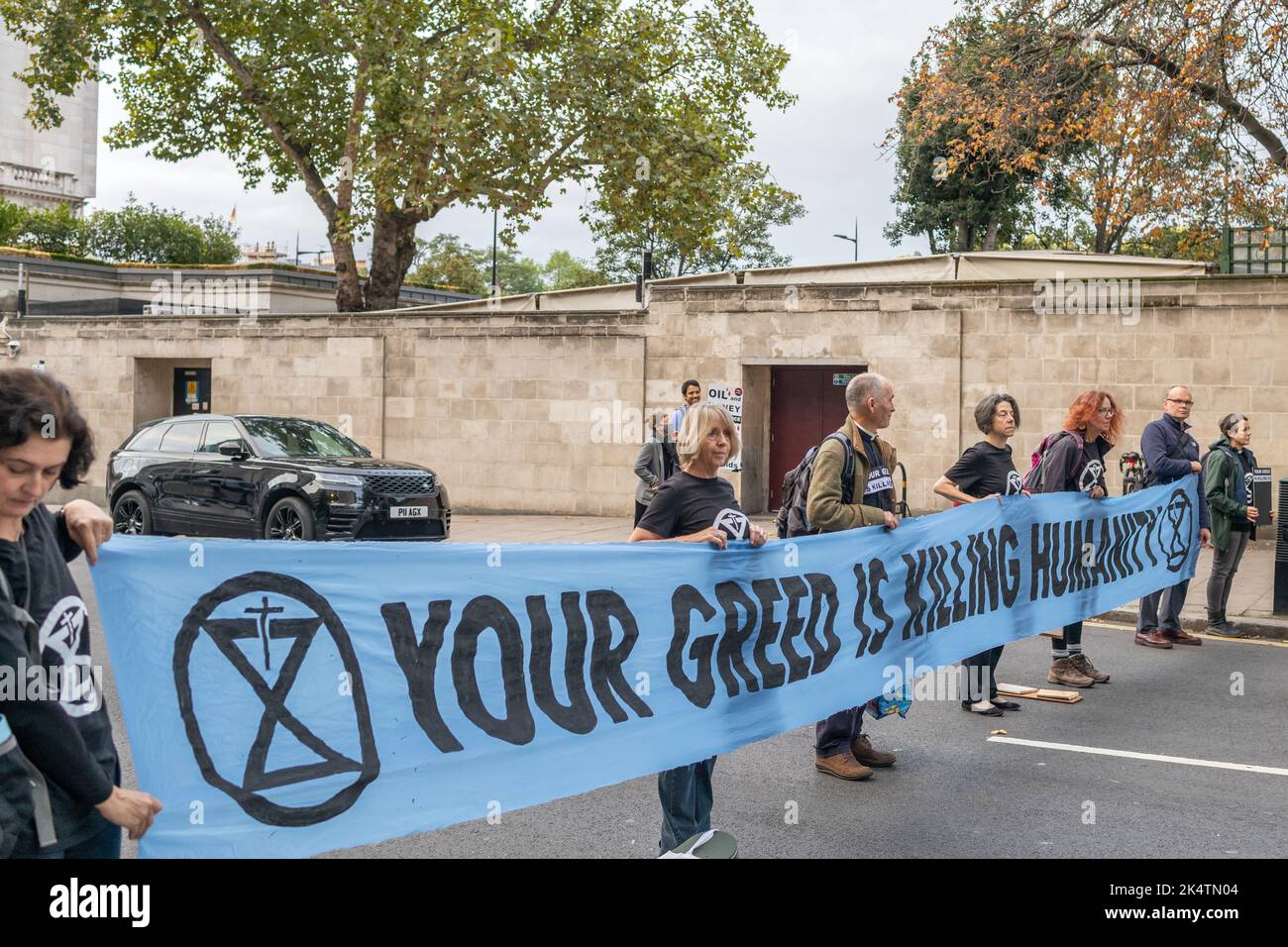 London, England, UK, 04/10/2022, A coalition of climate groups derail the start of the Energy Intelligence Forum (formerly the Oil and Money Forum) with road and door blocks at the Intercontinental Hotel, Park Lane. The coalition was made up of XR Youth, Extinction Rebellion, Money Rebellion, Christian Climate Action, Fossil Free London and Debt for Climate Credit: Denise Laura Baker/Alamy Live News Stock Photo