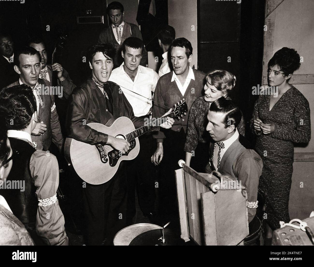 Hoyt Hawkins with (back to camera) takes part in a music number backstage with, Hugh Jarrett, Bill Black (holding upright bass), Elvis Presley, Scotty Moore at the top of picture, Ric Roman next to Elvis, Charles O'Curren, Patti Page, D.J. Fontana sat with his drum kit, and Liliane Montevecchi (Nina). Stock Photo